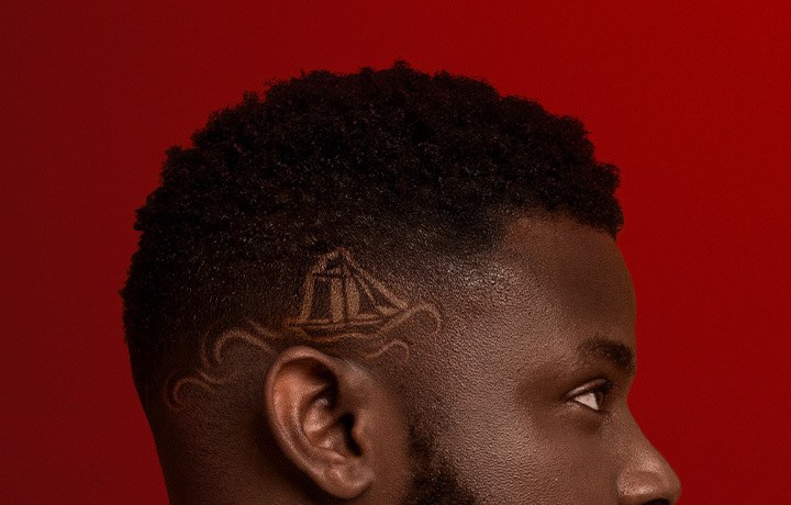 Man met het Old Spice-scheepje in zijn haar geschoren tegen een rode achtergrond